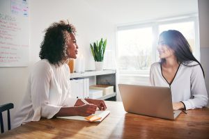 two-young-business-colleagues-having-a-discussion-NJRMDWE